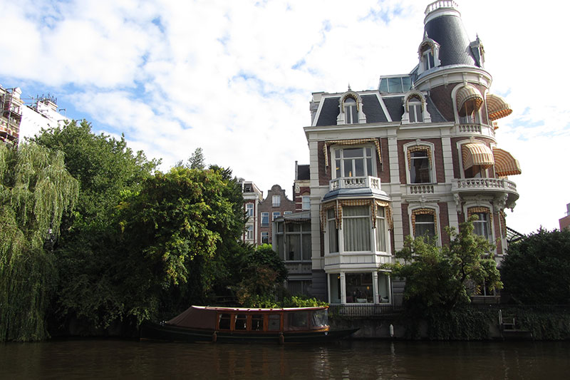 Casa y barco en un canal en las Postales de Holanda